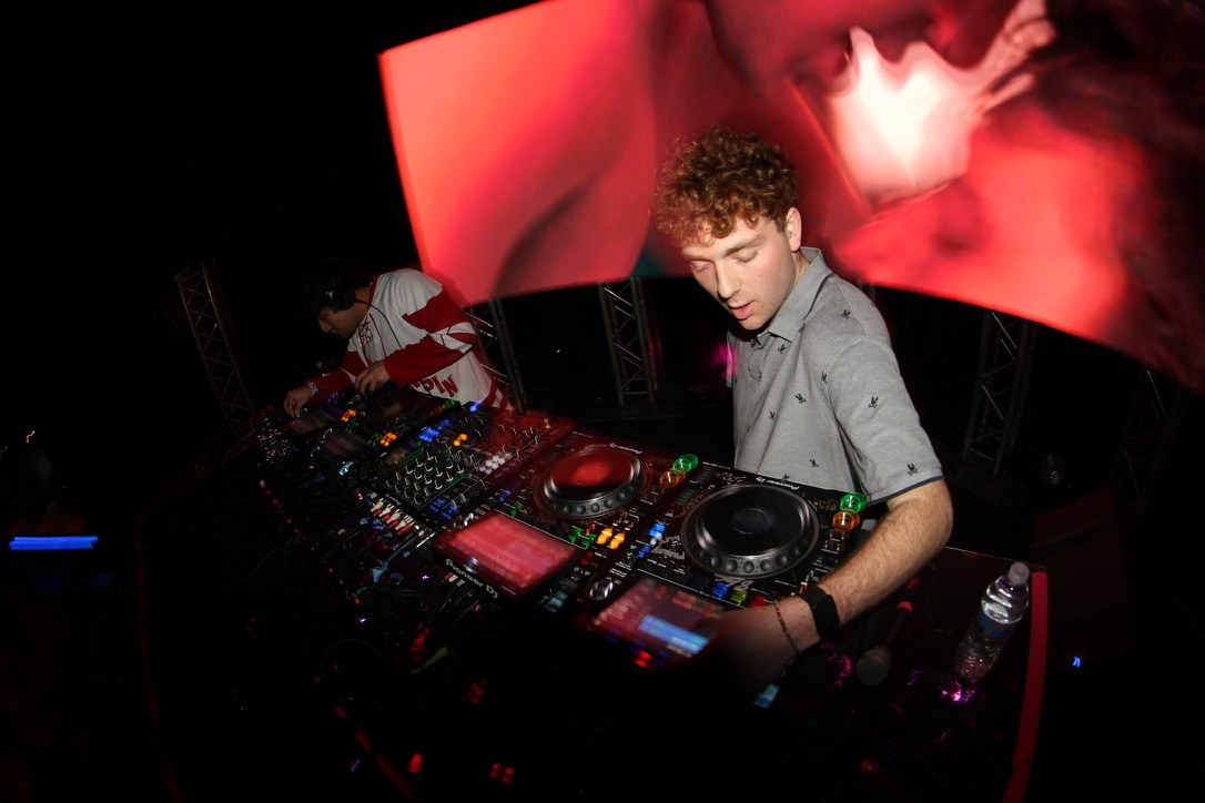 DJ mixing in front of a curved LED screen