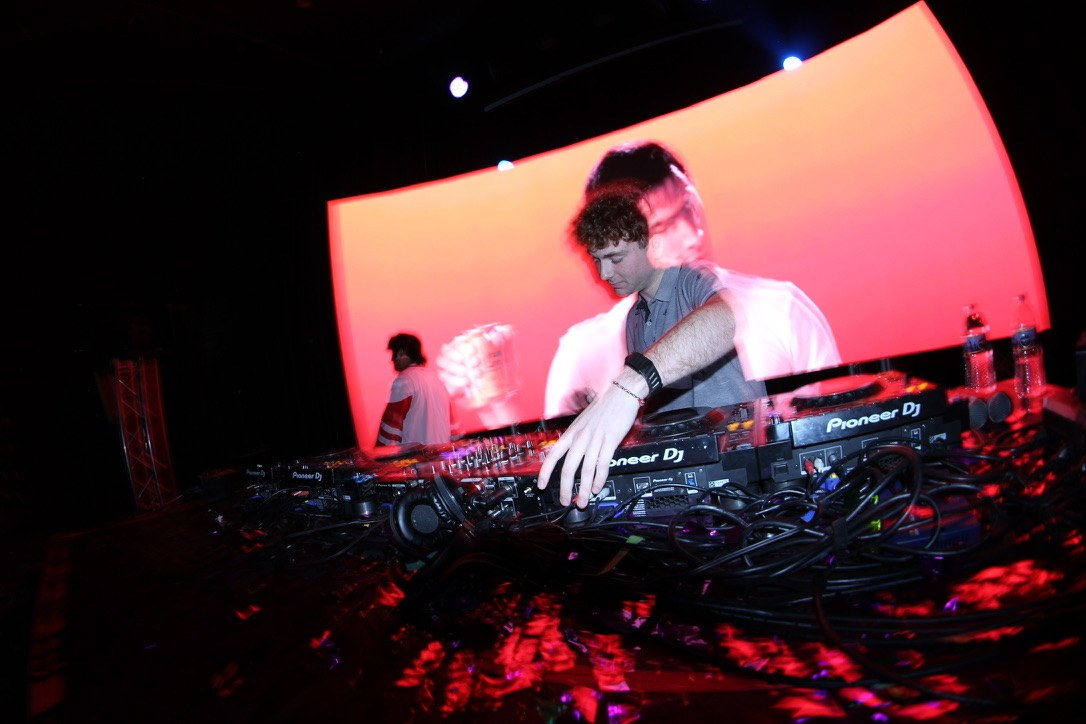 DJ performing in front of a pink LED wall