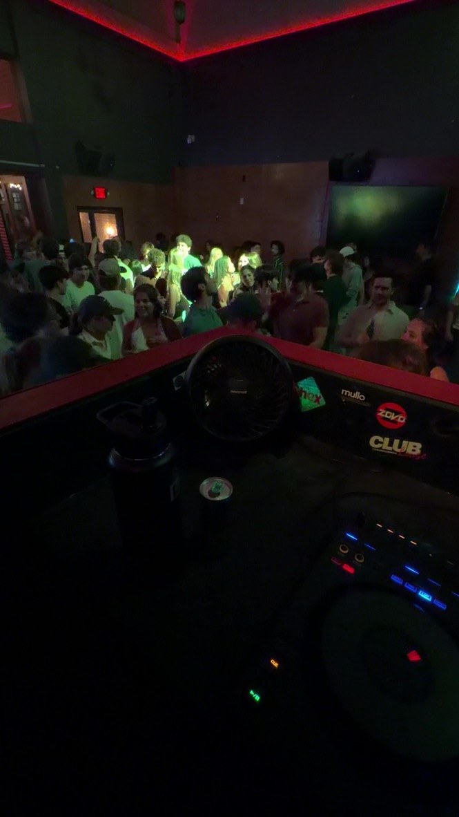 Crowd beyond the DJ booth with the controller in the foreground