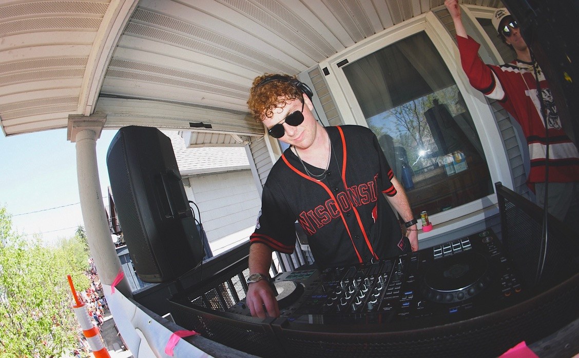 DJ in sunglasses playing a daytime set on a porch