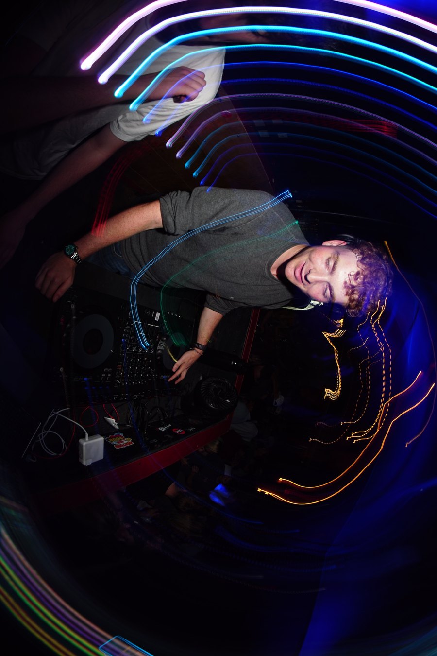 BENGAL mixing mid-set, eyes closed, wrapped in light trails